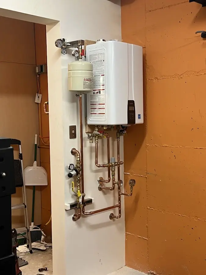 Plumbing technician inspecting water heater connections in Mason